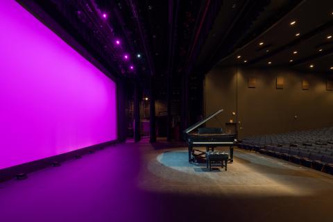 Campbell Hall on stage facing stage left featuring a piano at center stage