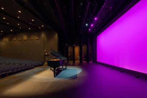 Campbell Hall on stage facing stage right featuring a piano at center stage