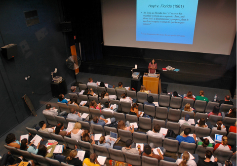 top down photo of people seated in a theater attending a lecture presentation