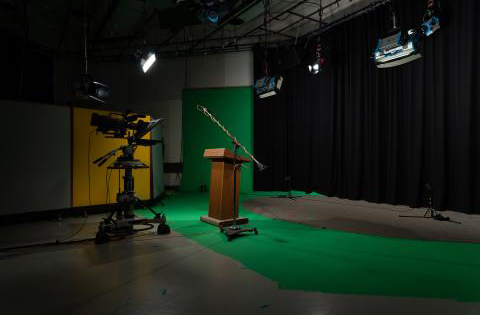 photo of a studio with a lectern and a green floor